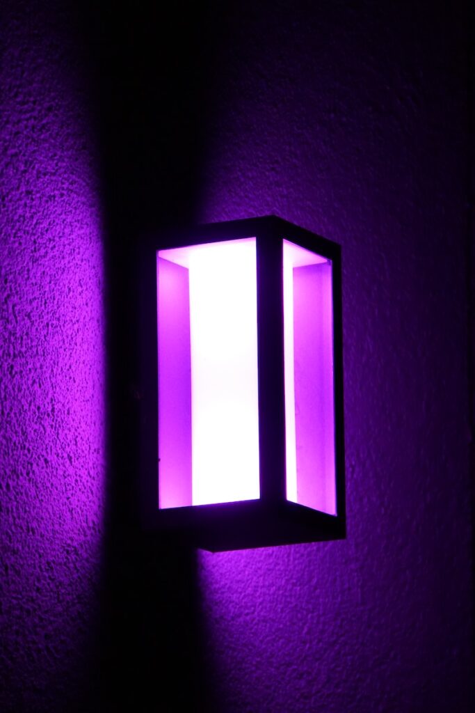 a purple light shines brightly on a wall